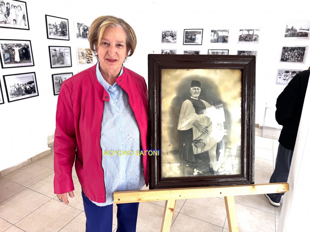 Η κ. Μπασμπανέλου δίπλα στη φωτογραφία με τον παππού της, Μιχάλη Μπασμπανέλο
